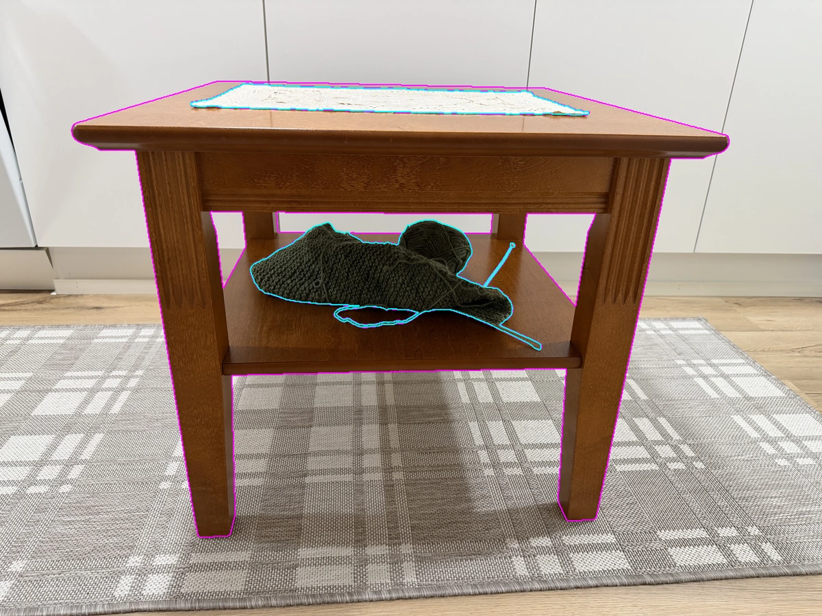 The original coffee-table photograph with a magenta table outline and cyan outlines around the tablecloth and knitting.